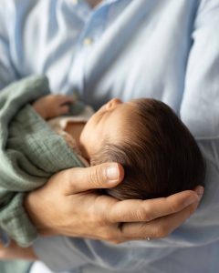 Nahaufnahme der Hand des Vater mit welcher er den Kopf seiner Tochter hält.