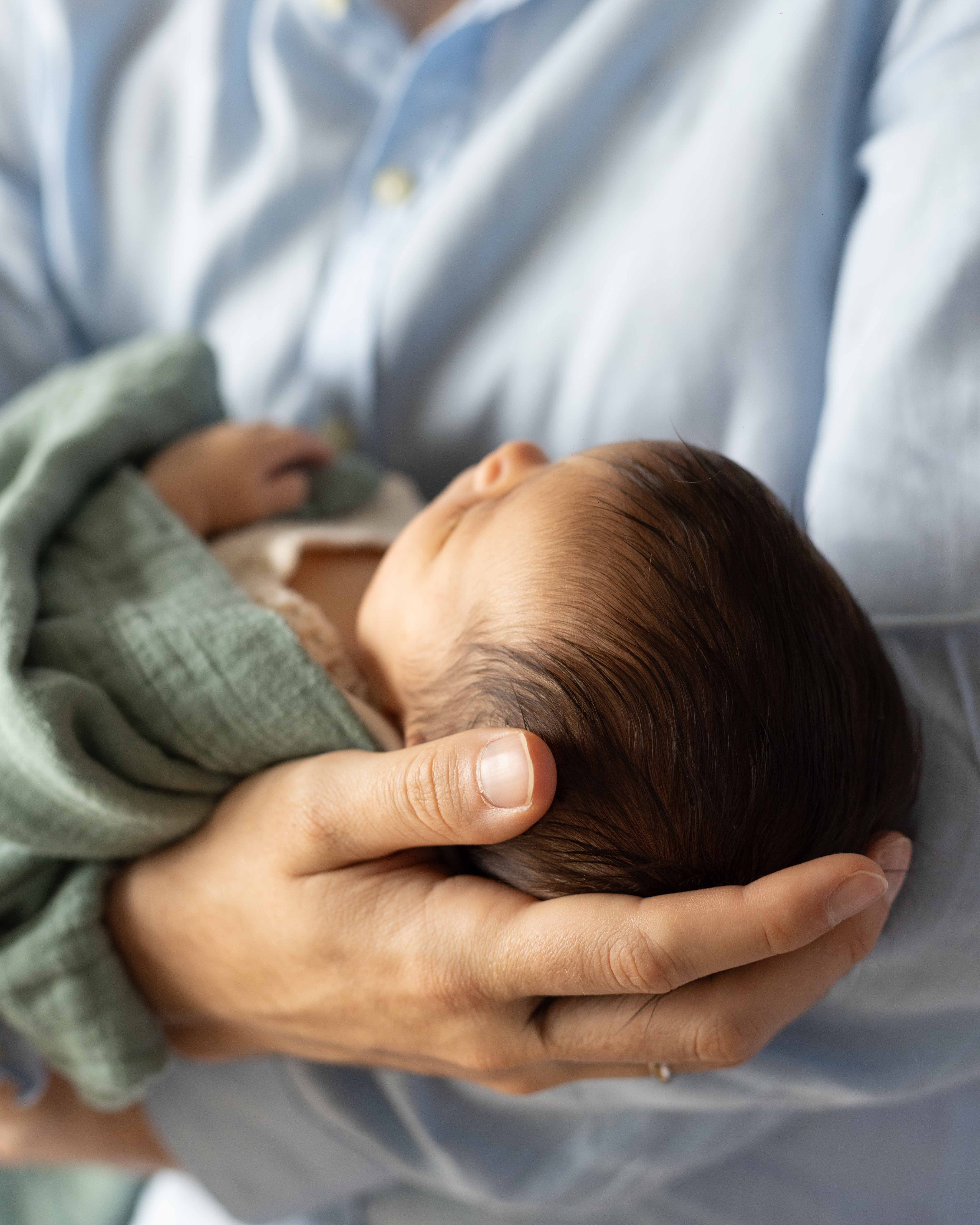 Nahaufnahme der Hand des Vater mit welcher er den Kopf seiner Tochter hält.